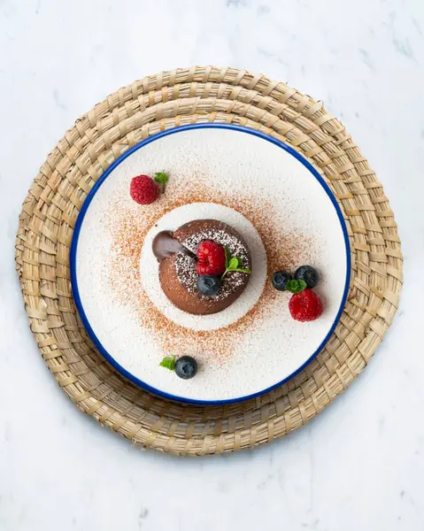 Çok güzel bir çikolatalı lav keki Noel süslemeleri ile birlikte en üstten görülebilir..