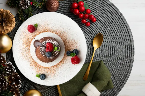 Çok güzel bir çikolatalı lav keki Noel süslemeleri ile birlikte en üstten görülebilir..