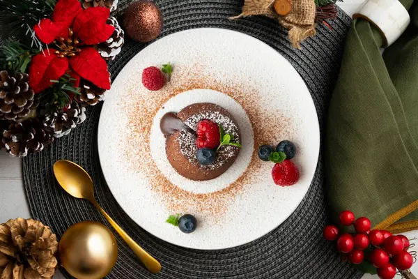 Çok güzel bir çikolatalı lav keki Noel süslemeleri ile birlikte en üstten görülebilir..