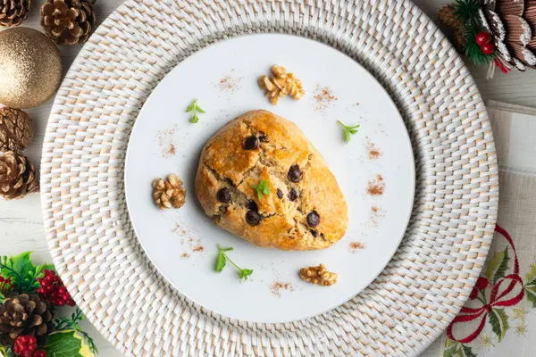 Koyu çikolata parçacıklı üçgen İngiliz çörekleri. Noel süslemeleri ile en üstteki görünüm masası.