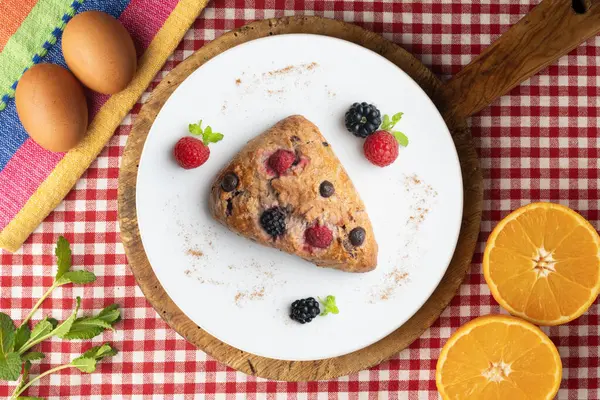 Böğürtlen, ahududu ve çikolata parçacıklı üçgen İngiliz çörekleri. Noel süslemeleri ile en üstteki görünüm masası.