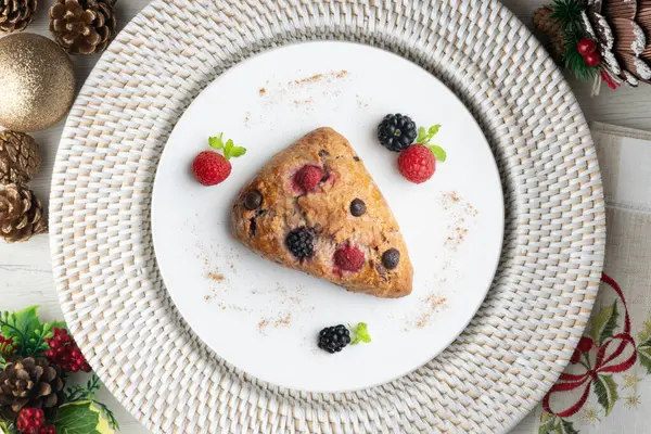Böğürtlen, ahududu ve çikolata parçacıklı üçgen İngiliz çörekleri. Noel süslemeleri ile en üstteki görünüm masası.