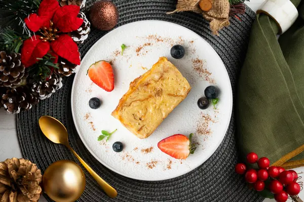 İbizan Greixonera. Balear Adaları 'ndan geleneksel ensaimada ile yumurtalı puding. Noel süslemeleri ile en üstteki görünüm masası.