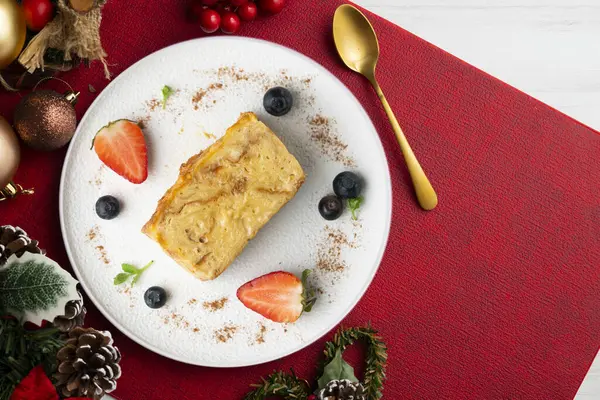 İbizan Greixonera. Balear Adaları 'ndan geleneksel ensaimada ile yumurtalı puding. Noel süslemeleri ile en üstteki görünüm masası.