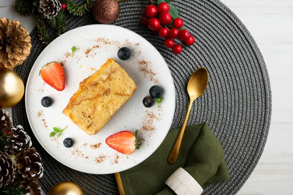 İbizan Greixonera. Balear Adaları 'ndan geleneksel ensaimada ile yumurtalı puding. Noel süslemeleri ile en üstteki görünüm masası.