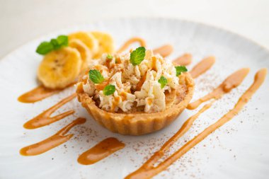 Karamelli banoffee turtası, taze muz ve krema..