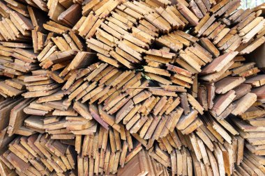 Düzensiz olarak istiflenmiş kereste soyut arka plan, evin inşasına hazırlanan eski ahşap tahtalar, birkaç tahta parçasının kenarındaki desen.