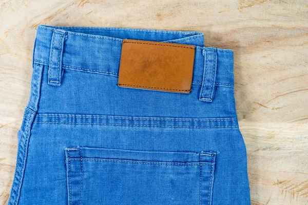 Brilliant leather blank on the back of blue jeans, Brown label on the waistband of jeans for wearing letters, denim backgrounds label clothes for sale, tags brand new pants label,