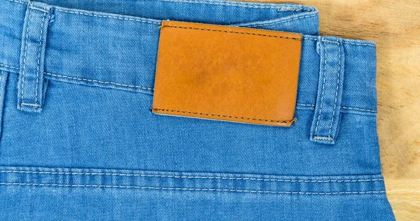 Brilliant leather blank on the back of blue jeans, Brown label on the waistband of jeans for wearing letters, denim backgrounds label clothes for sale, tags brand new pants label,
