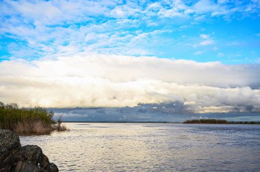 Sıcak bir yaz günü, beyaz bulutlar denizin üzerinde yüzüyor. Nehrin kıyısında..