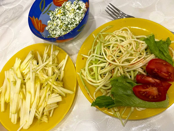 Bir tabak kabaklı spagetti. Kabak, beyaz arka planda şeritleri kes. Domates..