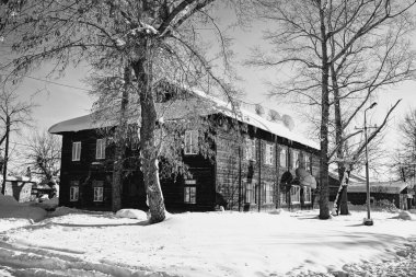 Kış yolu, ahşap eski bina. Kuru ağaçlar sokağı. Kırsalda bir ev.