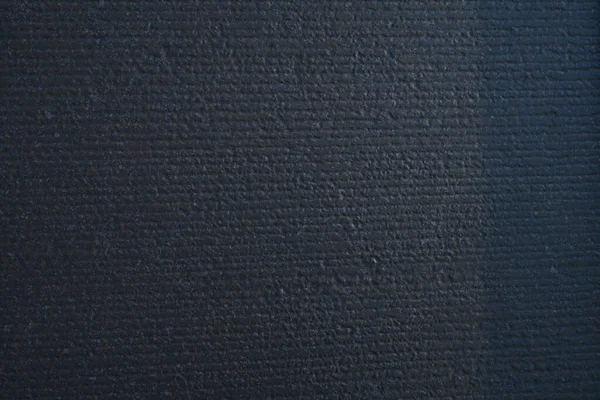 Dekoratif alçı efektli koyu gri bir duvar dokusu..