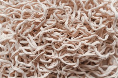 Tangled beige threads yarn noodles texture background