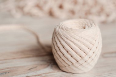 Skein of threads of beige noodle yarn, close-up