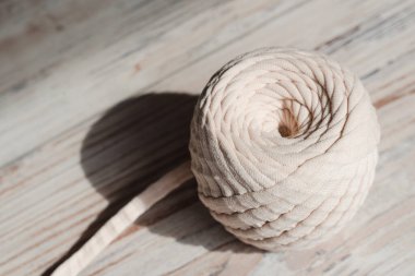 Skein of threads of beige noodle yarn, close-up