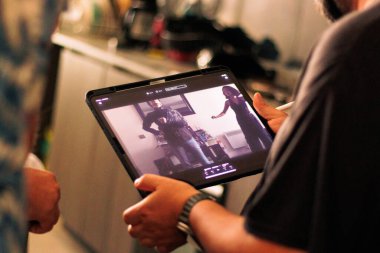 Bir görsel-işitsel yapım sahnesinin arkasında, filmleri kaydediyor ve onları ekranlar ve kameralar aracılığıyla izliyor. Yönetmen ve yapım ekibinin görüşü.