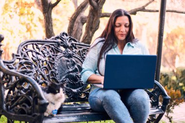 Evinden uzakta, arka bahçesinde dizüstü bilgisayarıyla, kedisinin yanında çalışan güzel bir Latin yönetici ona dokunuyor, neşe, şefkat. Teleçalışma, pazarlama.