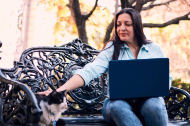 Evinden uzakta, arka bahçesinde dizüstü bilgisayarıyla, kedisinin yanında çalışan güzel bir Latin yönetici ona dokunuyor, neşe, şefkat. Teleçalışma, pazarlama.