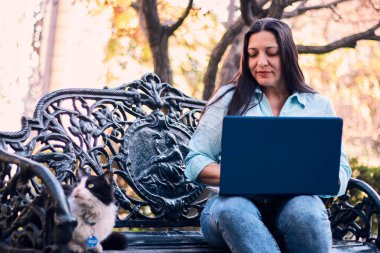 Evinden uzakta, arka bahçesinde dizüstü bilgisayarıyla, kedisinin yanında çalışan güzel bir Latin yönetici ona dokunuyor, neşe, şefkat. Teleçalışma, pazarlama.