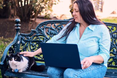 Evinden uzakta, arka bahçesinde dizüstü bilgisayarıyla, kedisinin yanında çalışan güzel bir Latin yönetici ona dokunuyor, neşe, şefkat. Teleçalışma, pazarlama.