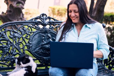 Evinden uzakta, arka bahçesinde dizüstü bilgisayarıyla, kedisinin yanında çalışan güzel bir Latin yönetici ona dokunuyor, neşe, şefkat. Teleçalışma, pazarlama.