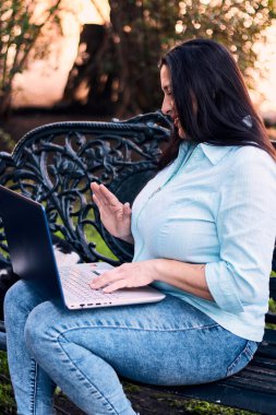 Evinden uzakta, arka bahçesinde dizüstü bilgisayarıyla, kedisinin yanında çalışan güzel bir Latin yönetici ona dokunuyor, neşe, şefkat. Teleçalışma, pazarlama.