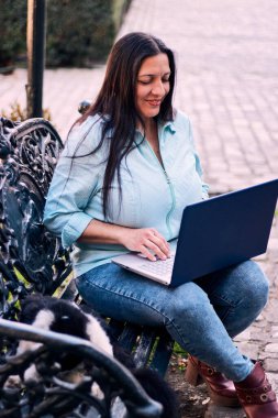 Evinden uzakta, arka bahçesinde dizüstü bilgisayarıyla, kedisinin yanında çalışan güzel bir Latin yönetici ona dokunuyor, neşe, şefkat. Teleçalışma, pazarlama.