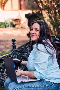 Evinden uzakta, arka bahçesinde dizüstü bilgisayarıyla, kedisinin yanında çalışan güzel bir Latin yönetici ona dokunuyor, neşe, şefkat. Teleçalışma, pazarlama.