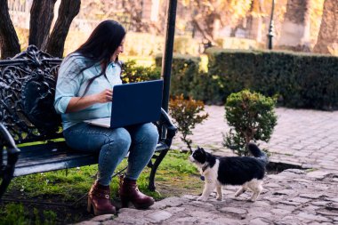Evinden uzakta, arka bahçesinde dizüstü bilgisayarıyla, kedisinin yanında çalışan güzel bir Latin yönetici ona dokunuyor, neşe, şefkat. Teleçalışma, pazarlama.