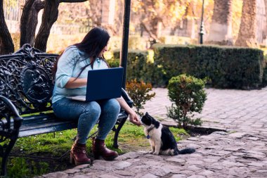 Evinden uzakta, arka bahçesinde dizüstü bilgisayarıyla, kedisinin yanında çalışan güzel bir Latin yönetici ona dokunuyor, neşe, şefkat. Teleçalışma, pazarlama.
