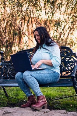 Evinden uzakta çalışan güzel bir Latin yönetici dizüstü bilgisayarıyla internete bağlanıyor. Joy, gülümse. Çevrim içi iş, pazarlama.