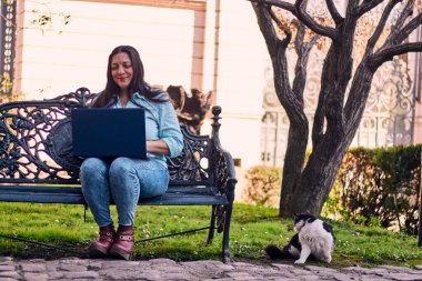 Evinden uzakta, arka bahçesinde dizüstü bilgisayarıyla, kedisinin yanında çalışan güzel bir Latin yönetici ona dokunuyor, neşe, şefkat. Teleçalışma, pazarlama.