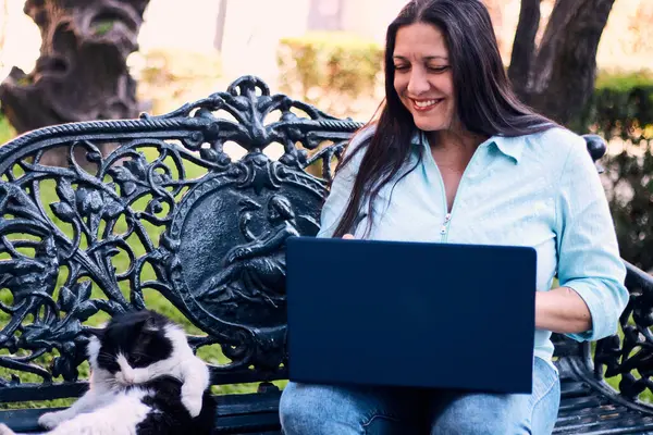 Evinden uzakta, arka bahçesinde dizüstü bilgisayarıyla, kedisinin yanında çalışan güzel bir Latin yönetici ona dokunuyor, neşe, şefkat. Teleçalışma, pazarlama.