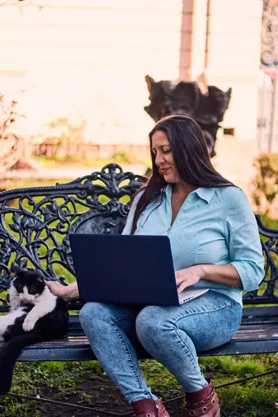 Evinden uzakta, arka bahçesinde dizüstü bilgisayarıyla, kedisinin yanında çalışan güzel bir Latin yönetici ona dokunuyor, neşe, şefkat. Teleçalışma, pazarlama.