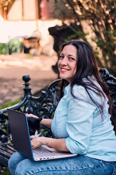 Evinden uzakta, arka bahçesinde dizüstü bilgisayarıyla, kedisinin yanında çalışan güzel bir Latin yönetici ona dokunuyor, neşe, şefkat. Teleçalışma, pazarlama.