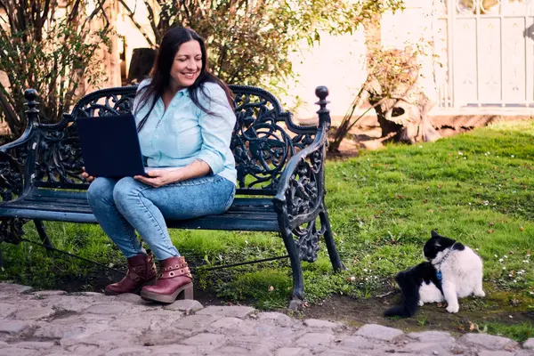 Evinden uzakta, arka bahçesinde dizüstü bilgisayarıyla, kedisinin yanında çalışan güzel bir Latin yönetici ona dokunuyor, neşe, şefkat. Teleçalışma, pazarlama.