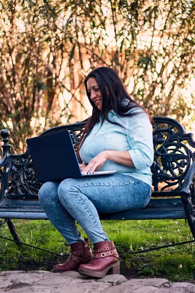 Evinden uzakta çalışan güzel bir Latin yönetici dizüstü bilgisayarıyla internete bağlanıyor. Joy, gülümse. Çevrim içi iş, pazarlama.