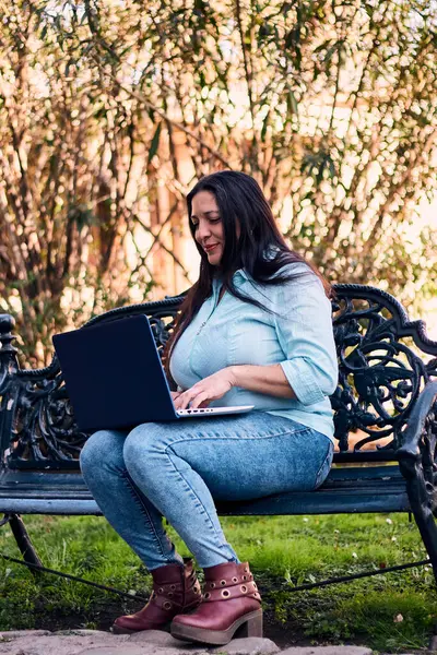 Evinden uzakta çalışan güzel bir Latin yönetici dizüstü bilgisayarıyla internete bağlanıyor. Joy, gülümse. Çevrim içi iş, pazarlama.