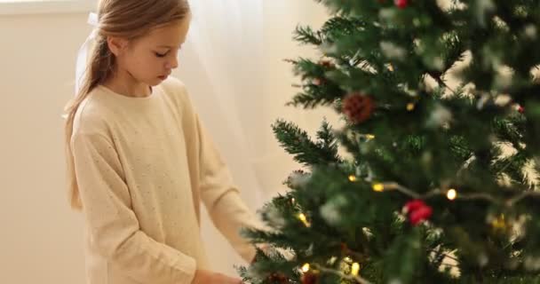 她的女儿装饰着圣诞树 幸福的家庭 圣诞节 孩子们在圣诞节前夕玩耍 假日庆祝 高质量的4K镜头 — 图库视频影像
