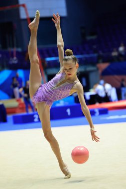 Yetenekli bir ritmik jimnastikçi zarif bir spor müsabakasında denge, zarafet ve yetenek gösterir.