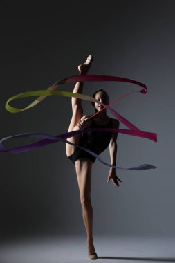 Büyüleyici bir dansçı büyüleyici bir kurdele dansı performansıyla zarafet ve sanatını sergiliyor.