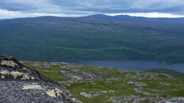 Nehir kıyısındaki dağlardan köye video görüntüsü. Peyzaj 4K panoramik dağ görüntüleri