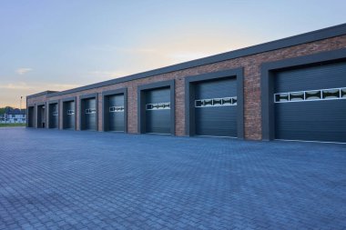Nakliye şirketleri için tasarlanmış geniş bir garaj kompleksi, depolama, park ve lojistik için birden fazla birim sunuyor. Ticari araç yönetimi için pratik bir çözüm