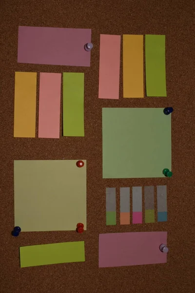 Blank sticky notes with pins on pinboard