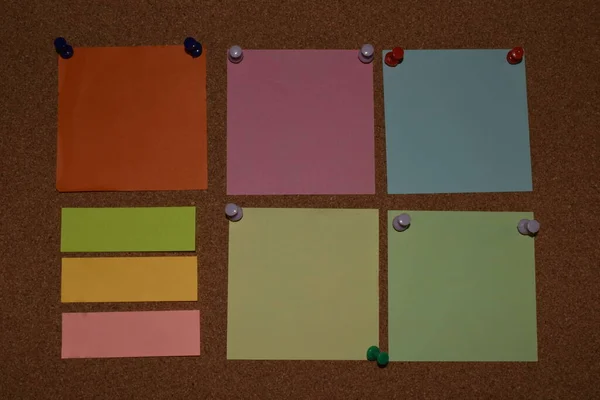 Blank sticky notes with pins on pinboard