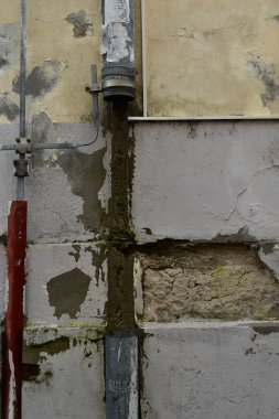 Old damaged brick wall concept background with rusty gutter 