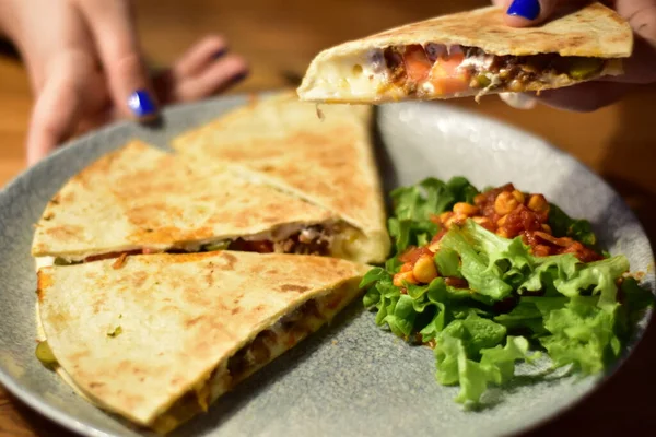 Detail of a vegan burrito and quesadilla with avocado on a fancy plates in a restaurant