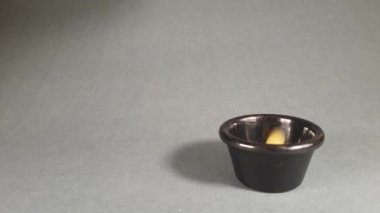 Throwing uncooked pasta in a black bowl from above, on a black background