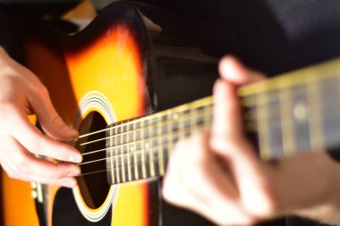 Playing acoustic guitar passionately close up photography